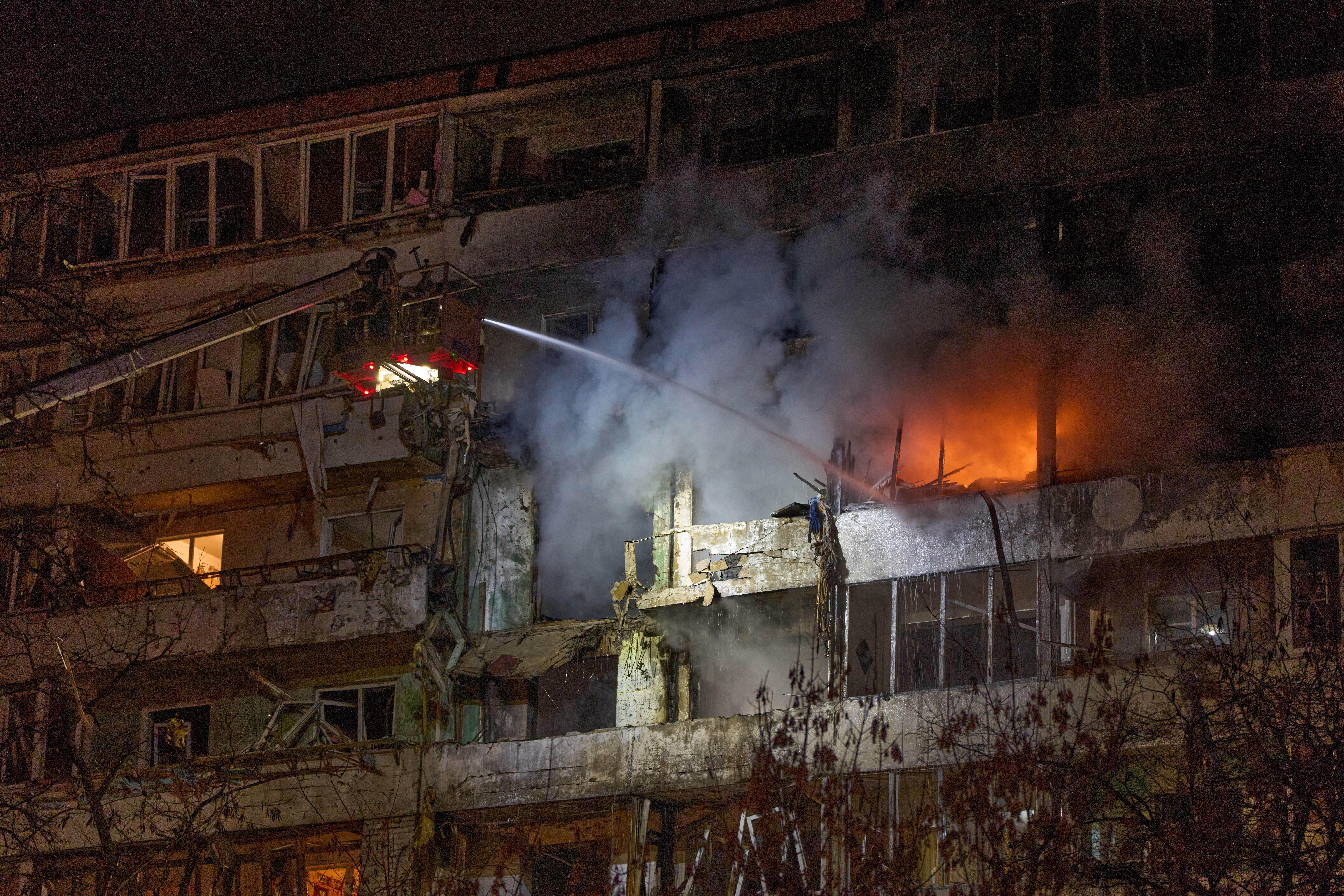 Firefighters put out the fire after a drone hit a multi-storey residential building during Russia